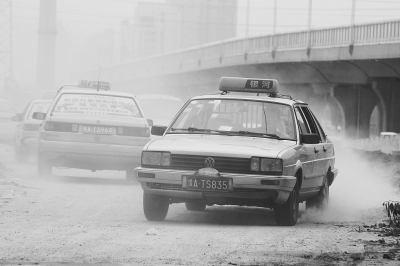 施工的道路上，車輛通過塵土飛揚(yáng)。