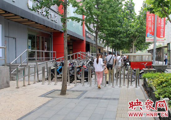 圖中道路左側(cè)的無障礙通道被鋼管隔離,右側(cè)的盲道也被侵占。