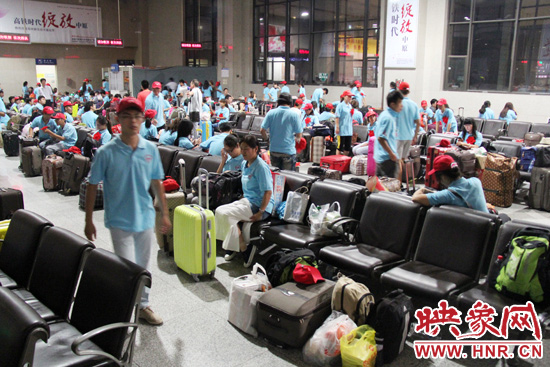 大學生志愿者在火車站候車室內整裝待發(fā)。