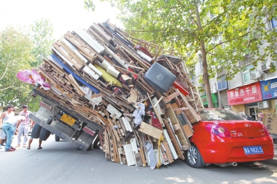 紅色小轎車被砸，卡在路邊動彈不得。