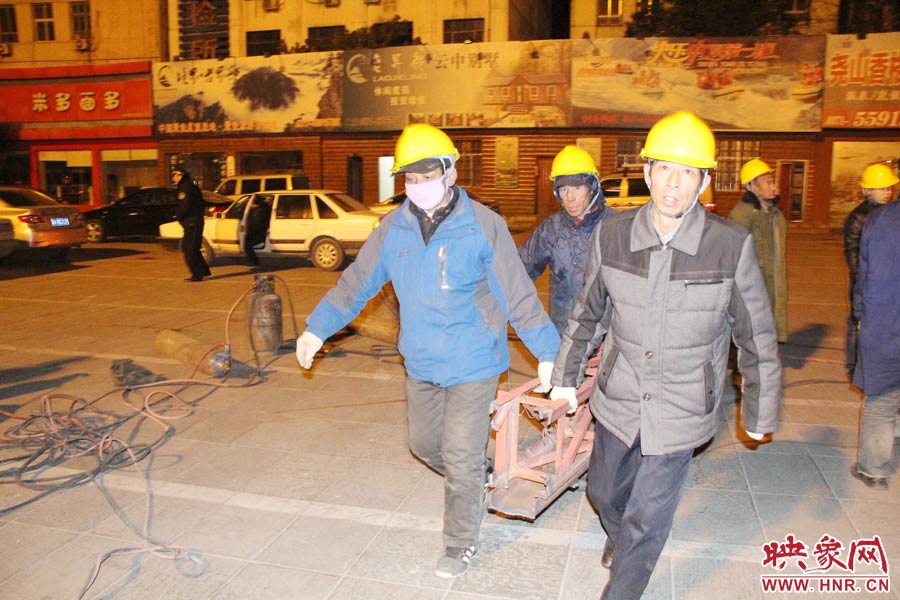 23點(diǎn)56分，第一塊兒廣告牌已經(jīng)分割完畢，地面上的20多名工人將拆除下來的鋼件撞車運(yùn)走。