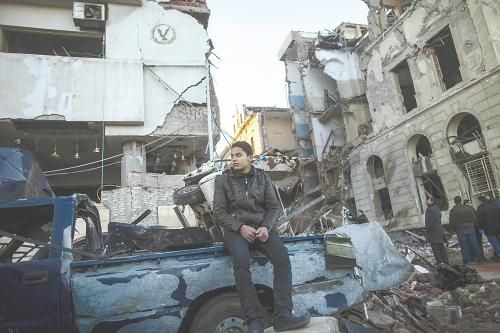 埃及曼蘇拉市警察局24日遭汽車炸彈襲擊，被疑是穆兄會的報復。圖為一名男子在被炸毀的警察局前。