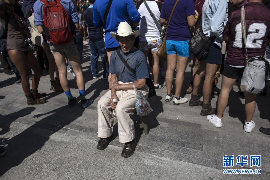 一名男子坐在參加不穿褲子搭地鐵的人群邊小憩。