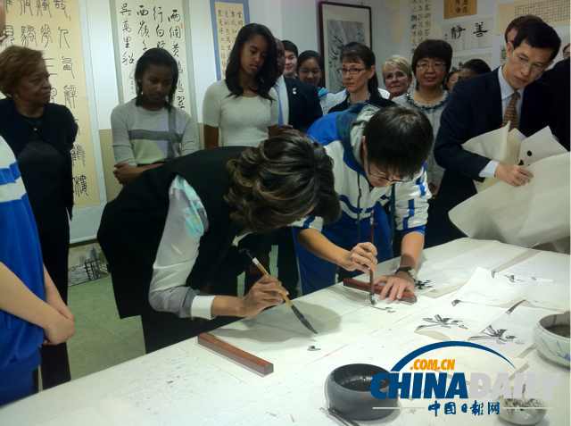 　北京時間3月21日，美國第一夫人米歇爾參觀北師大二附中時，與學(xué)生一起練習(xí)書法。