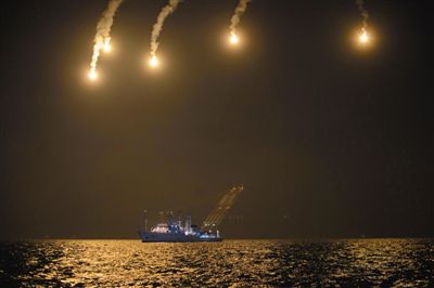 22日，搜救人員在照明彈的光亮下連夜搜救。