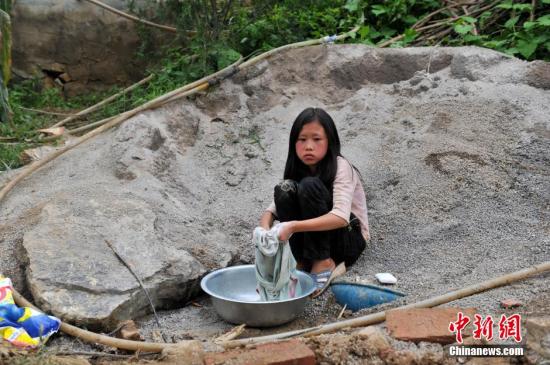 8月9日，云南巧家紅石巖村，10歲的劉鑫蕊在洗自己的衣服