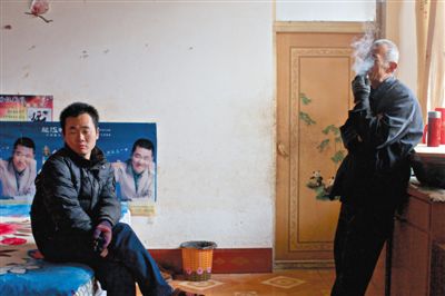 父親抽煙，兒子不語。逃跑的越南新娘，給袁迎賓父子帶來的是失落。新京報記者