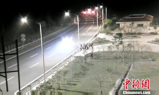 看到車輛經(jīng)過(guò)，孩子們便急忙跑到一旁的花圃上?！【焦﹫D　攝