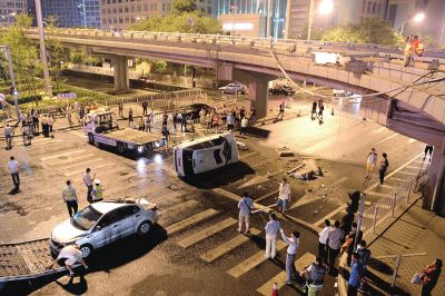 路虎沖下國(guó)貿(mào)橋砸中一輛起亞轎車，橋上厚達(dá)幾十厘米的水泥護(hù)欄被撞斷，碎石四處散落，數(shù)十群眾在現(xiàn)場(chǎng)圍觀。