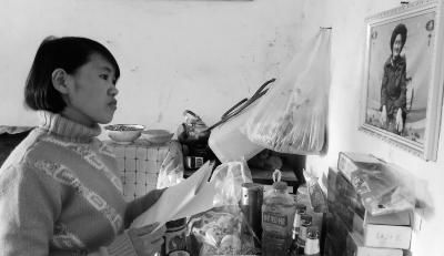 錢仁鳳站在母親遺像前。未能見母親最后一面是她的一大遺憾。