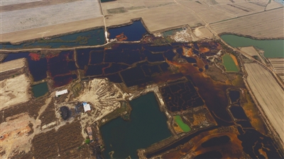 4月19日，廊坊市大城縣南趙扶鎮(zhèn)，津保路以北約八九百米處，一個(gè)巨大的污水坑中，水體呈現(xiàn)紅褐色。 新京報(bào)記者 尹亞飛 攝