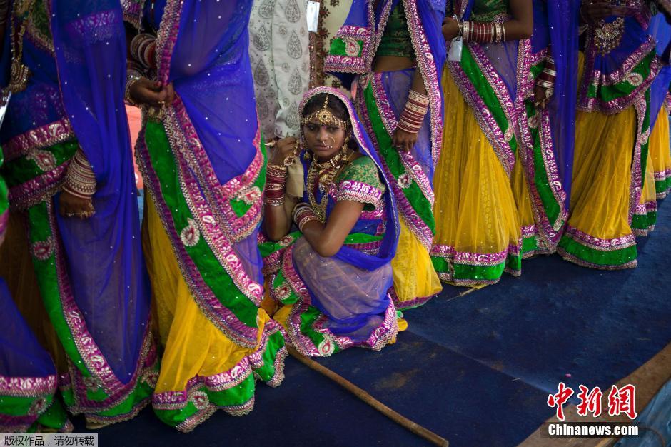 當(dāng)?shù)貢r(shí)間2014年6月15日,印度新德里,印度政府為數(shù)百對(duì)貧困新人舉辦集體婚禮。