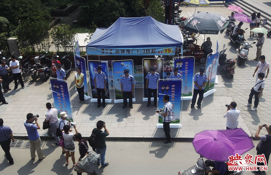 執(zhí)法人員用宣傳牌圍擋占道經(jīng)營攤位。