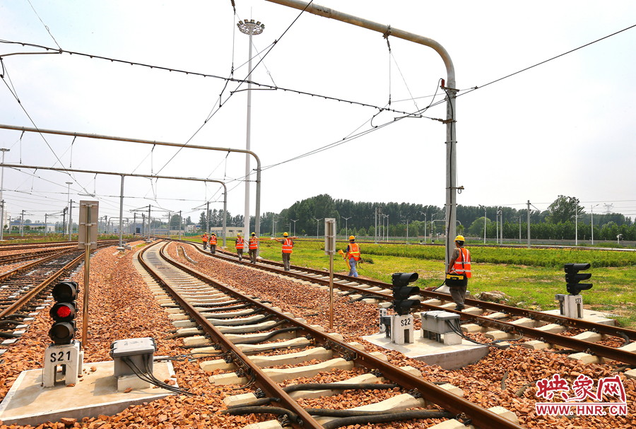在太陽(yáng)的直射下，檢修工人扛著沉重的設(shè)備向施工地點(diǎn)出發(fā)