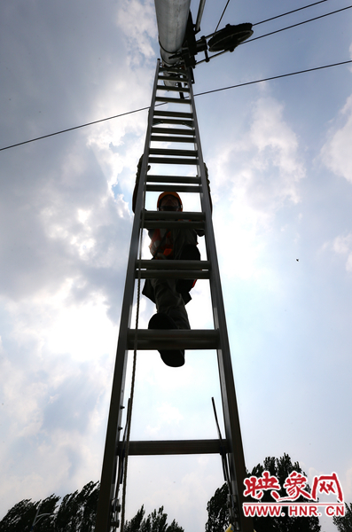 頂著太陽(yáng)的直射，檢修工不斷要爬上高處施工