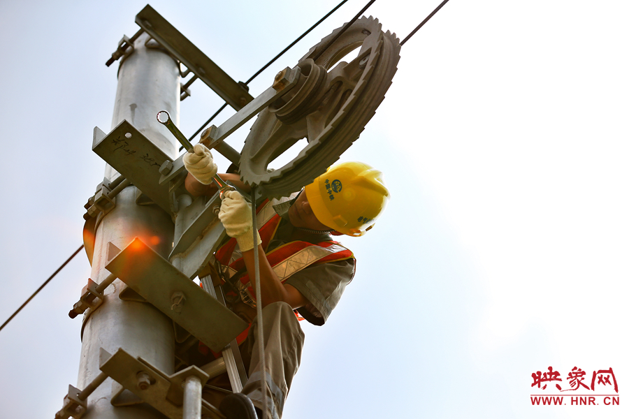被太陽(yáng)暴曬后的線桿碰著就能燙紅皮膚，可是檢修員此刻也顧不得許多