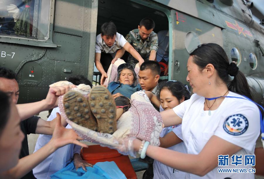 8月5日，醫(yī)護人員將一名通過直升機從震中轉(zhuǎn)運出來的傷員運下飛機。