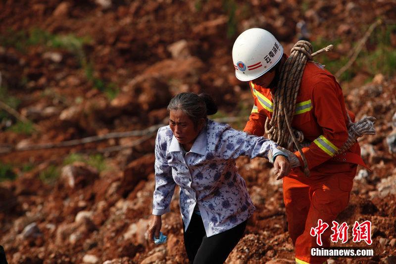 一位消防戰(zhàn)士將一位失去親人的老人扶離滑坡點(diǎn)。