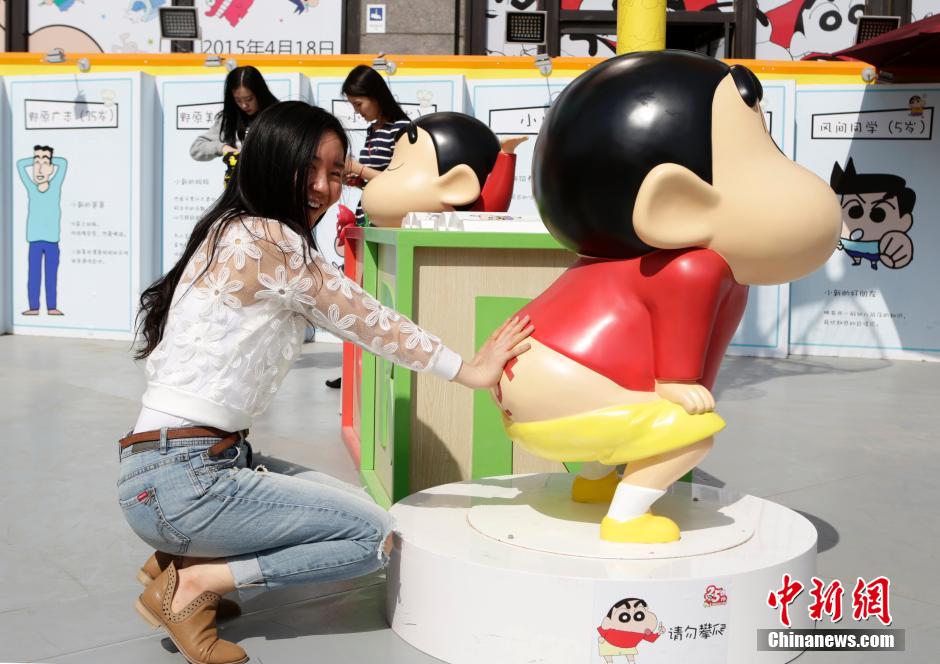 4月22日，游客與蠟筆小新合影。“蠟筆小新25周年紀(jì)念特展”日前在北京開展，吸引了不少市民游客。