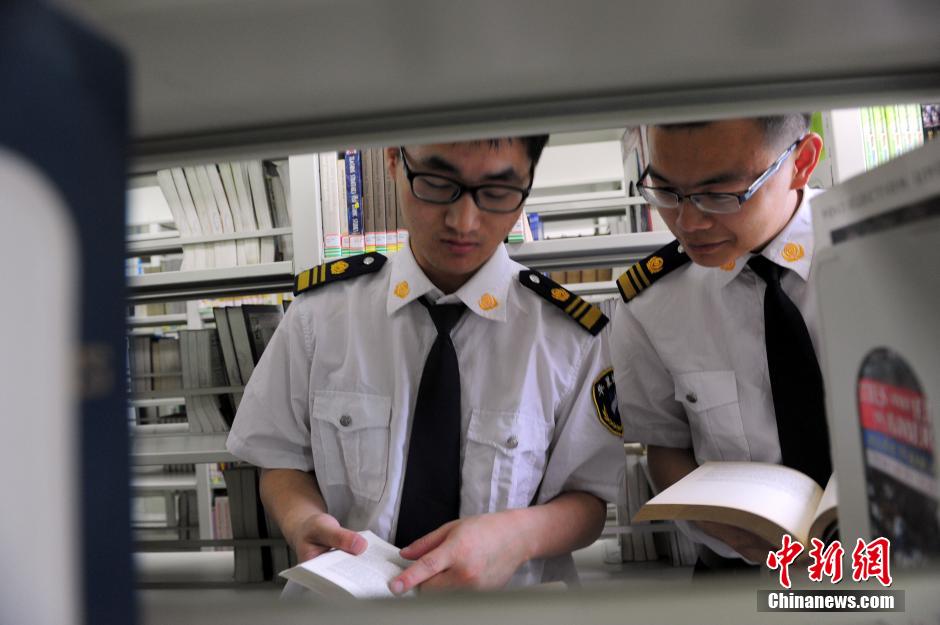 5月8日，武漢輕工大學(xué)圖書館保安吳濤與江力在圖書館交流學(xué)習(xí)。