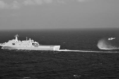 11日，抵達馬航飛機失聯(lián)海區(qū)的海軍井岡山艦與艦載直升機協(xié)同展開立體搜救行動。新華社發(fā)