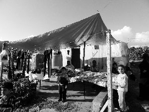 黎巴嫩一敘利亞難民營(yíng)，難民支起攤鋪賣衣服掙錢。