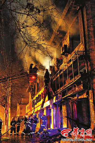 昨日22時(shí)10分，西安市豐慶路南小巷南口，消防官兵架梯子登上二樓施救 本組圖片由本報(bào)記者 閆文青 攝