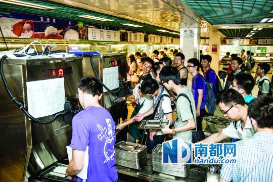 昨日，華南理工大學(xué)一食堂內(nèi)，學(xué)生們正在使用新安裝的自動打飯機(jī)打飯。中新社發(fā)