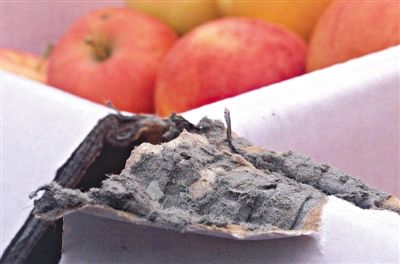 8月29日，新發(fā)地市場，一箱用“加重紙箱”包裝的蘋果正待售，紙箱夾層內灰黑色的增重填充物清晰可見