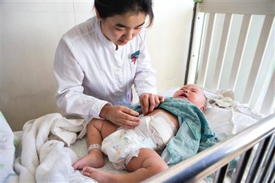 昨日，北京兒童醫(yī)院，護(hù)士為即將出院的被扎鋼針女嬰檢查傷口恢復(fù)情況。記者 高瑋 攝