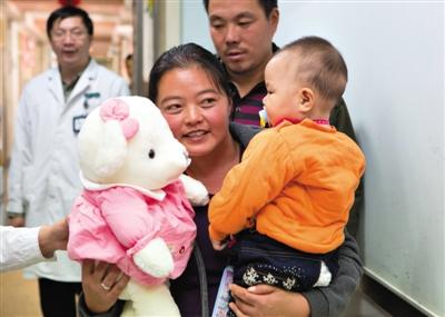 昨日上午，被扎針女嬰的母親抱著孩子和醫(yī)護(hù)人員送的玩偶準(zhǔn)備出院，院方稱孩子術(shù)后恢復(fù)良好。記者 高瑋 攝