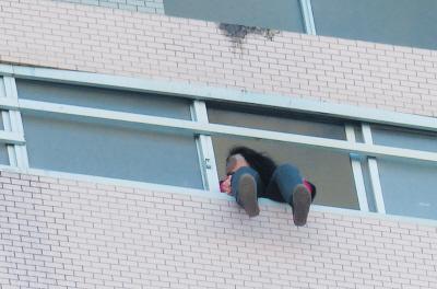 28樓的窗臺(tái)上坐著一名女子，其兩條腿耷拉在室外，不停地?cái)[動(dòng)。