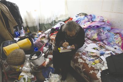 圖為老人在紙片上寫著尋找小女兒的啟事 圖為老人在紙片上寫著尋找小女兒的啟事