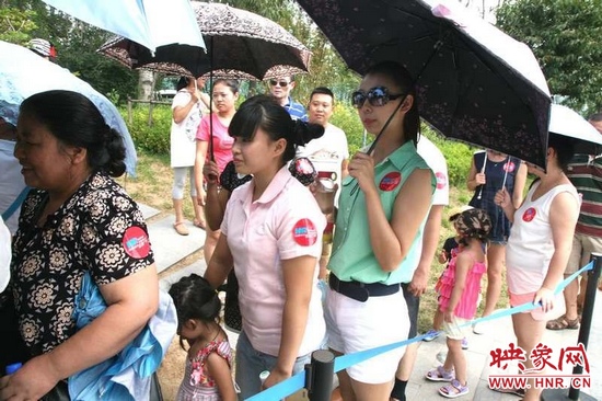 佩戴信息廣播臂貼的聽眾們?cè)谂抨?duì)等候坐帆船。