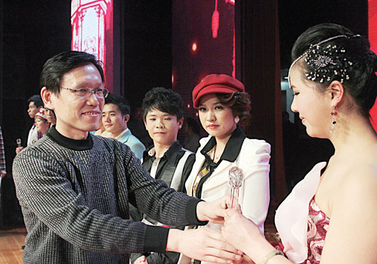 2013年2月1日，《對(duì)9當(dāng)歌》總決賽在鄭州開(kāi)唱。圖為東方今報(bào)副社長(zhǎng)胡楊為選手頒獎(jiǎng)