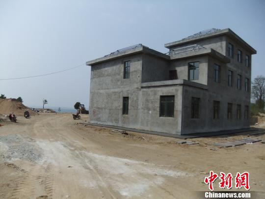 鴨河水庫庫區(qū)邊的新建別墅，一面墻上寫著“拆”，另一邊在加緊施工。吳揚　攝