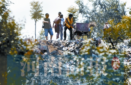 有人正在傾倒建筑垃圾，不遠(yuǎn)處就是村民的水井